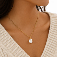 Collier en acier doré avec fermoir anneau, perle baroque surdimensionnée centrale, petites perles latérales décoratives, fermoir à bascule, bijou cadeau pour femme
