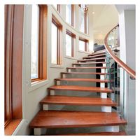 Escalier courbé sur mesure Prima Custom Home avec marches en bois massif lumineuses et structure en acier durable pour une rénovation moderne