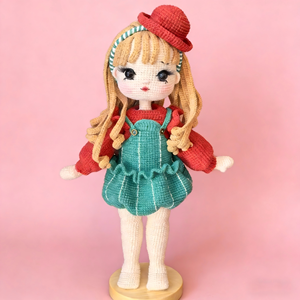 Muñeca Mila Tejida a Mano, con Sombrero Rojo y Vestido Verde con Tirantes, Pelo Largo Amarillo y Aproximadamente 32 cm de Altura - Product Image 1