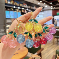 Al por mayor Llavero de moda ligero de cristal con cereza, de resina brillante con diseño de fruta y aleación de oro, colgante para bolso y llavero para coche