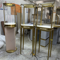 Vitrine à bijoux haute sur mesure, vitrine à bijoux en acier doré avec verre incurvé, éclairage LED, logo, boutique, usine OEM