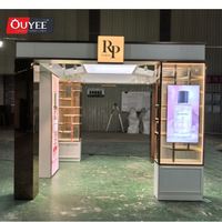 Kiosque de présentation de parfums et cosmétiques moderne, luxueux, pliable et rotatif en 3D avec éclairage LED et thème rose pour les centres commerciaux