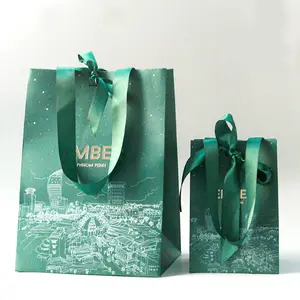 Sacchetti di carta opaca di lusso alla rinfusa per regali e shopping, adornati con un logo, su misura per l'imballaggio di abbigliamento personalizzato.