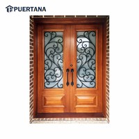 Porte d'entrée en bois massif sur mesure avec grille décorative en fer forgé et design en fonte pour l'extérieur