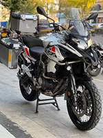 Moto de tourisme d'aventure à deux cylindres refroidie par eau de 502 cm3, blanche et noire, avec bagages et barres de protection entièrement en aluminium