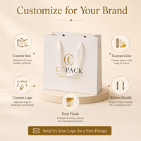 Sac en papier cartonné blanc personnalisé avec poignée en ruban, logo en feuille d'or, finition mate pour l'emballage de vêtements de boutique, vente en gros