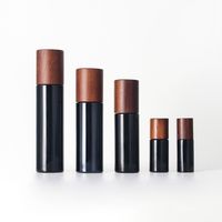 Nuevo frasco de vidrio redondo oscuro con tapa de abeto y dosificador, con bomba para loción, serigrafía y logotipo personalizado, para set cosmético y cuidado de la piel.