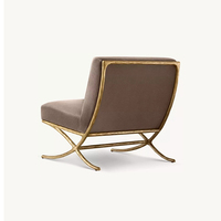 Fauteuil d'appoint moderne de luxe en velours taupe, sans accoudoirs, avec base en X texturée bronze, fauteuil lounge minimaliste pour salon et mobilier d'hôtel