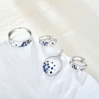 Ensemble de bijoux fins QX en argent 925 plaqué rhodium, avec pendentif disque asymétrique pavé de CZ bleus et blancs et bagues créoles larges ouvertes