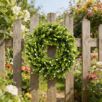 Minimalistische groene krans met kleine witte bloemen voor gebruik in de lente, zomer en het hele jaar door