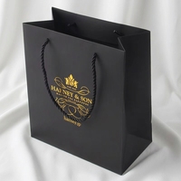 Sac cadeau en papier noir mat haut de gamme avec poignée en ruban gros-grain noir, logo de marque personnalisé, revêtement UV, sac d'expédition pour institut de beauté et spa
