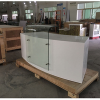 Comptoir de réception personnalisé haut de gamme, moderne, durable, en Corian blanc, avec façade en verre, de forme légèrement incurvée, pour usage hospitalier