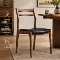 Chaise de salle à manger en bois massif avec dossier à double lattes et coussin noir sur pieds coniques pour restaurant, brasserie et salon de thé