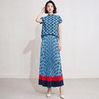 Ensemble deux pièces plissé Miyake : Haut à manches courtes à col montant imprimé floral géométrique bleu et jupe plissée rouge marine