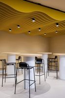 Traitement acoustique de plafond en feutre PET absorbant le son, avec déflecteurs superposés à lignes ondulées et fluides pour un rythme et un mouvement sonores