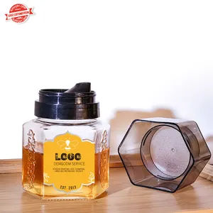 China Grote Fabriek Goede Prijs Groothandel Zeshoekige Lint Snijwerk Glazen Pot Voor Honing Met Plastic Deksel