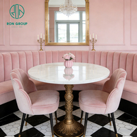 Ensemble de mobilier de restaurant et café : Sièges de banquette incurvés élégants à capitonnage vertical, chaise en velours rose, table ronde en pierre frittée