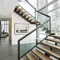 Escalier moderne flottant pour cuisine extérieure, avec garde-corps en verre, marches en bois, monopoutre droite et éléments en acier inoxydable