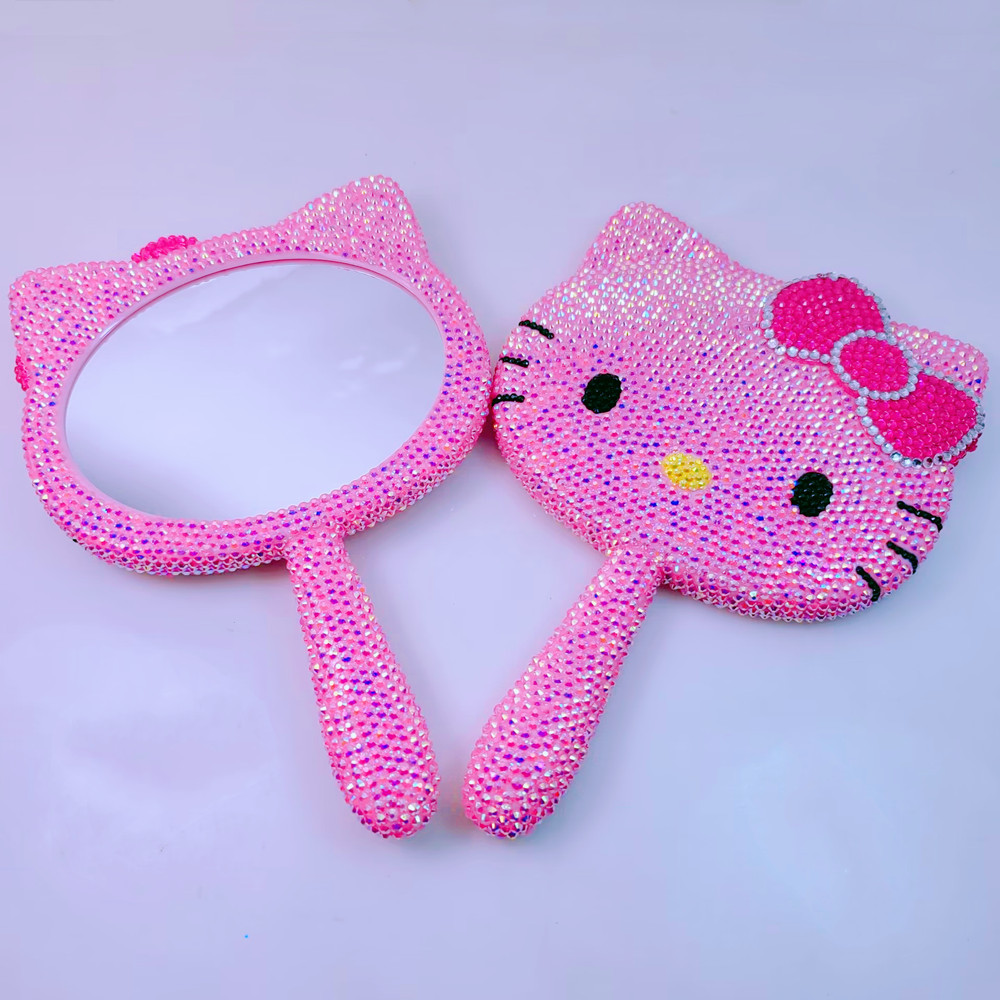 Specchio con manico rosa interamente tempestato di diamanti.