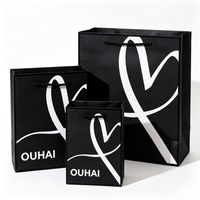 Sac cadeau en papier noir personnalisé avec logo imprimé blanc, poignées torsadées noires, sac fourre-tout tendance pour l'emballage d'accessoires de mode