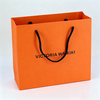 Fabricants de sacs en papier orange pour cosmétiques, parfums et maquillage, emballages cadeaux personnalisés, design boutique de luxe.