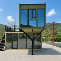 Maison préfabriquée contemporaine en conteneur à deux étages, avec toit en pente imitation bois, mur entièrement vitré et design cantilever.