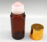 Flacon roll-on vide en verre ambré de 30 ml et 50 ml avec bille en quartz rose, emballé dans un carton sérigraphié