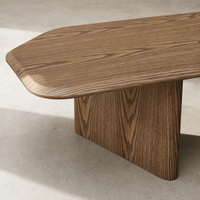 Table basse en bois grainé avec finition placage, silhouette allongée aux coins arrondis et pieds en panneaux pour mobilier de salon