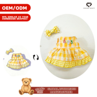 Peluche Teddy ISLAND sous licence mondiale, modèle énergique, avec robe brodée à carreaux jaune et blanc et nœud à carreaux