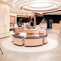 Ensemble de mobilier pour boutique de cosmétiques roses : table de vente incurvée avec grille intégrée et socle circulaire