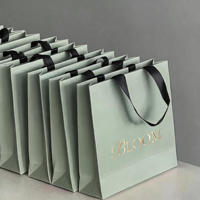 Sac en papier texturé noir gaufré de luxe 2026 avec logo personnalisé et poignée en ruban gros-grain pour emballage cadeau