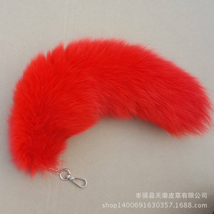 Cola de zorro blanco de unos 40 cm teñida de rojo.