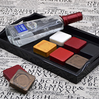 Divers blocs colorés de cire de cachetage de bouteille de vin de trempage de main