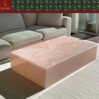 Table basse GOLDKING en onyx rose translucide avec veines rose clair et blanches pour un centre de table de luxe dans le salon, utilisation artistique