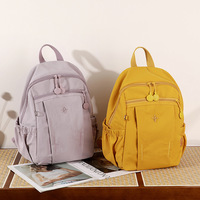 Sac à dos léger en nylon avec plusieurs poches zippées et compartiments latéraux élastiques, idéal pour l'école, les voyages ou le quotidien