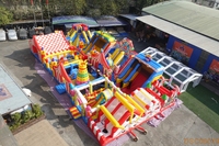Parc d'attractions gonflable sur le thème du carnaval avec toboggans et jeux interactifs, aire de jeux commerciale pour événements en plein air