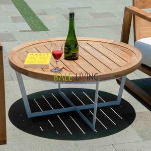 La mesa redonda Cattalina tiene una base robusta de hierro y aluminio, con una superficie de madera de teca de alta calidad. - Product Image 6