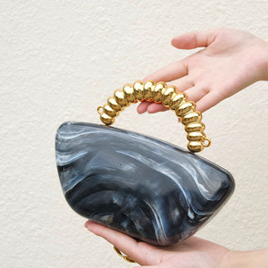 Bolso de mano de acrílico marmoleado estilo francés con asas de cuentas doradas y cierre magnético, que exuda una elegancia suave, refinada y minimalista para la noche. - Product Image 1