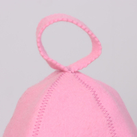 Un gorro de sauna rosa de lana pura con un hexágono verde en el pecho que mantiene el calor tan lejos como una memoria lejana.