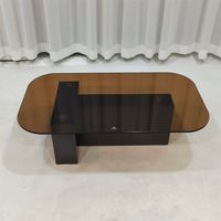 Table basse ovale avec plateau en verre fumé et base en acier inoxydable noir