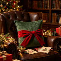 Coussin carré décoratif en velours vert foncé avec nœud rouge, idéal pour les fêtes de Noël et l'ambiance festive à la maison