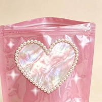 Pochette d'emballage refermable à fermeture éclair holographique rose brillant avec logo personnalisé, bordure perlée et fenêtre transparente en forme de cœur pour bijoux