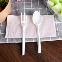 Ensemble de couverts jetables écologiques biodégradables en PLA avec couteau, fourchette, cuillère et serviette, emballés individuellement pour une utilisation en fête