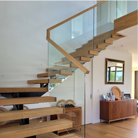 Escalier flottant moderne et minimaliste sur mesure avec monopoutre de luxe, marches en bois massif et garde-corps en verre pour intérieur