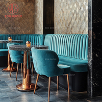 Ensemble de meubles de luxe pour café, restaurant, canapé en velours bleu incurvé, tables rondes à plateau texturé et fauteuils assortis