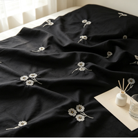Tissu polyester noir mat avec broderie de petites fleurs dispersées, fil blanc, centres de perles dorées, doux et respirant, pour filles et garçons