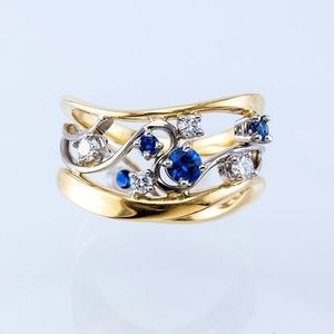 Anillo de Diamantes en Oro Amarillo para Mujer F392 con Piedras Laterales de Zafiro, Corte Brillante Redondo, Color G Natural, Joyería de Compromiso - Product Image 1