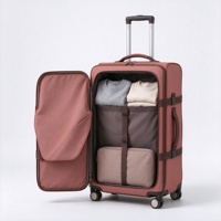 Valise à roulettes souple rouge rouille avec poche avant à rabat à boucle, sangles de compression et poignée télescopique