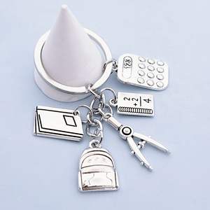 Accessoires de mode : Mini <span class=keywords><strong>sac</strong></span> <span class=keywords><strong>à</strong></span> <span class=keywords><strong>dos</strong></span> pendentif en métal étanche, motif dessin animé, avec calculatrice, règle et livre – Cadeau <span class=keywords><strong>pour</strong></span> la Fête des Enseignants et le début du nouveau semestre - Product Image 3