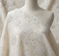 Tissu tissé de poids moyen avec broderie florale ajourée blanche et accents de perles tubulaires en sequins argentés pour abayas et hijabs de mariage